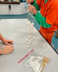 youth building tower out of pasta and marshmallows